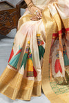 A detailed close-up of the Vanya Sarees pallu, showing the colorful print of Rajasthani puppets and the gold brocade border.