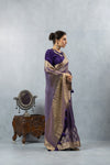 An elegant side profile of the model wearing the Vanya Sarees purple and gold Banarasi silk saree, showcasing its rich drape.