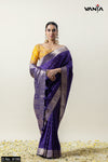 A full front view of the model in Vanya Sarees' magnificent royal purple Katan Banarasi silk saree with a contrasting yellow blouse.