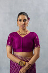 A clear front view of the Vanya Sarees readymade designer blouse in magenta purple, showing the V-neck and delicate sleeve embroidery.