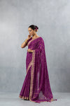 An elegant side profile of the model in the Vanya Sarees purple Bandhani saree, showcasing its fluid drape and detailed border.