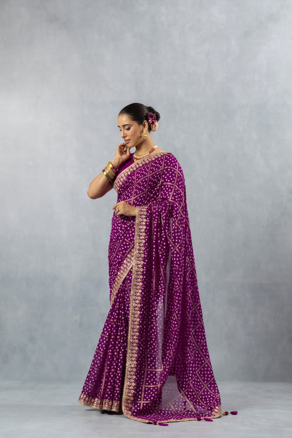 An elegant side profile of the model in the Vanya Sarees purple Bandhani saree, showcasing its fluid drape and detailed border.