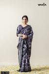 Full-length view of a model wearing Vanya's premium purple and grey geometric print crepe silk saree against a neutral backdrop.