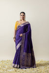 An elegant pose of the model in the Vanya Sarees royal purple Banarasi silk saree, perfect for a wedding or reception look.