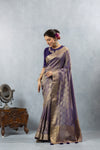 An elegant pose of the model in the Vanya Sarees purple woven Banarasi silk saree, perfect for a wedding or reception.