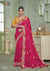 A full-length view of the model in Vanya Sarees' magnificent rani pink saree with a heavy, multi-color embroidered border and yellow blouse.