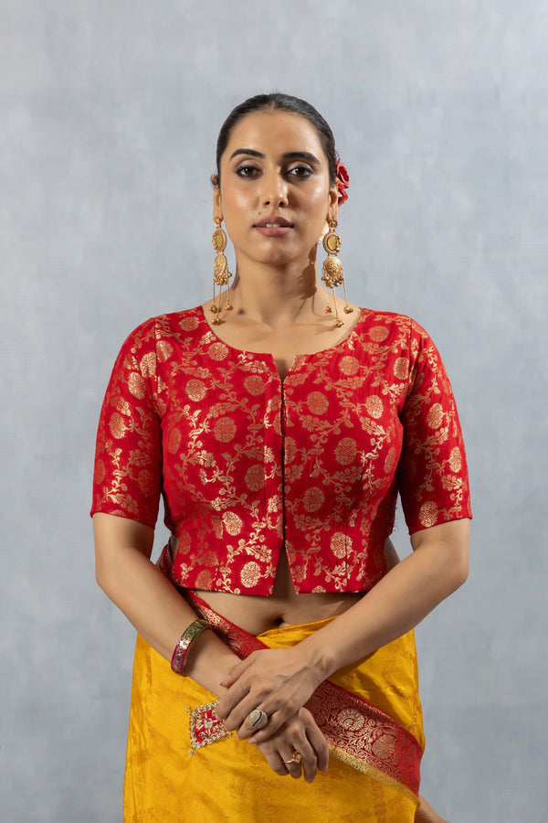A clear front view of the Vanya Sarees readymade designer blouse in red Banarasi brocade with a gold zari floral pattern.