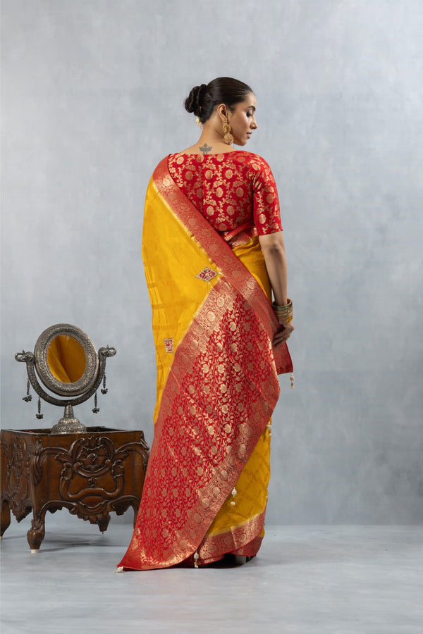A full back view of the model displaying the magnificent red and gold woven Banarasi pallu of the Vanya Sarees silk saree.