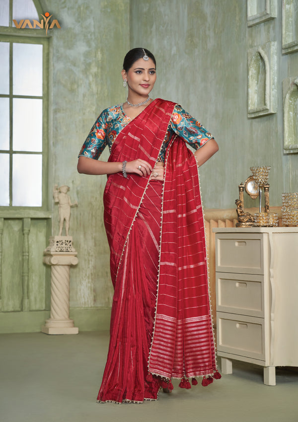 A full-length view of the model in Vanya Sarees' elegant red crushed georgette saree with a contrasting teal Kalamkari print blouse.