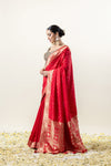 A beautiful side profile of the model wearing the Vanya Sarees red Katan silk saree, showing its rich texture and luxurious drape.