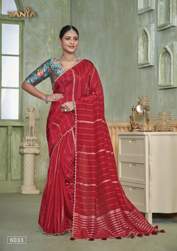 An elegant standing pose of the model showcasing the complete designer look of the Vanya Sarees red saree and artistic teal blouse.