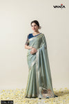 Full front view of a model in Vanya Sarees' elegant sage green linen silk saree with a navy blue designer brocade blouse.