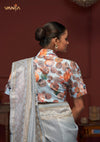 Back view of the model highlighting the beautiful abstract botanical pattern of the designer blouse from Vanya Sarees, paired with the light blue linen saree.