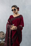 Upper body close-up of Vanya Maroon Saree, focusing on the heavy brocade section draped over the arm and styled with sunglasses.