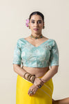 A clear front view of the sea green embroidered designer blouse with a V-neck, from the Vanya Sarees chiffon saree set.