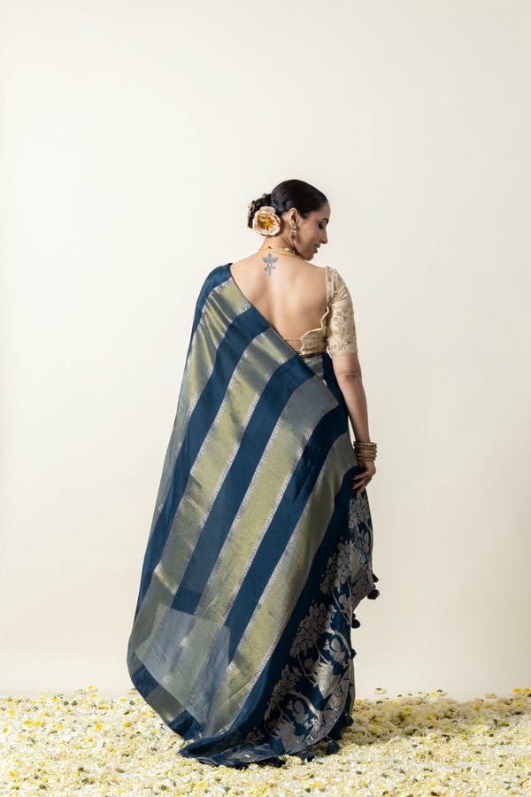 A full back view of the model in the Vanya Sarees ensemble, displaying the woven striped pallu and the deep back of the embroidered blouse.