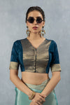 A clear front view of the Vanya Sarees readymade designer blouse in teal blue, showing the V-neck and brocade panel.