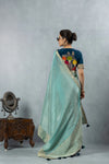 A full back view of the model in the Vanya Sarees ensemble, displaying the drape of the tissue silk pallu and the artistic embroidered blouse.