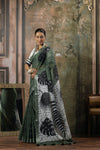 Model showcasing the beautiful drape and artistic tropical print of the Vanya Sarees olive green linen cotton saree pallu.