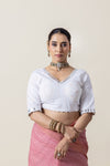 A clear front view of the readymade white designer blouse from Vanya Sarees, showing the intricate mirror work on the V-neckline.