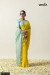 Full view of a model in sunglasses wearing Vanya Sarees' dual-tone yellow and sea green chiffon saree with Gota Patti work.