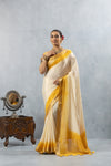 An elegant standing pose of the model in the Vanya Sarees yellow ombre tissue silk saree, perfect for a wedding or Haldi ceremony.