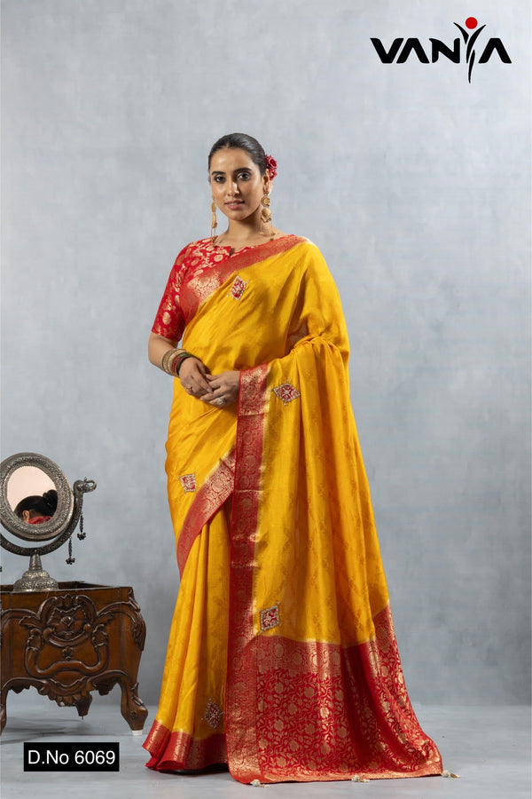 A full-length view of the model in Vanya Sarees' auspicious yellow and red Katan Banarasi silk saree.