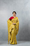 An graceful standing pose of the model in the Vanya Sarees lime yellow and gold striped saree, perfect for a reception or Sangeet.